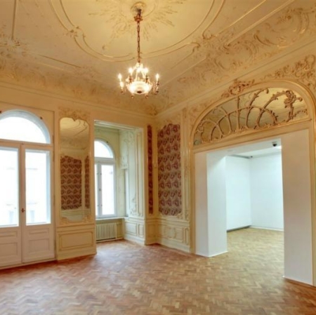 Pałacowe wnętrze utrzymane w jasnych kolorach z bogato zdobionymi ścianami i sufitem