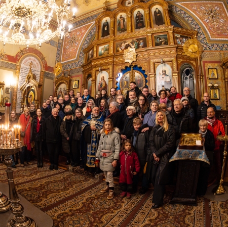 Photo in the church after panikhid for Katarzyna Kobro. People in several rows and wearing winter clothes stand in front of a richly decorated altar.