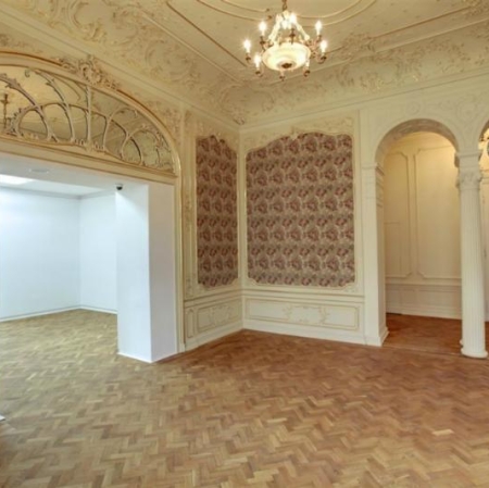 Pałacowe wnętrze utrzymane w jasnych kolorach z bogato zdobionymi ścianami i sufitem