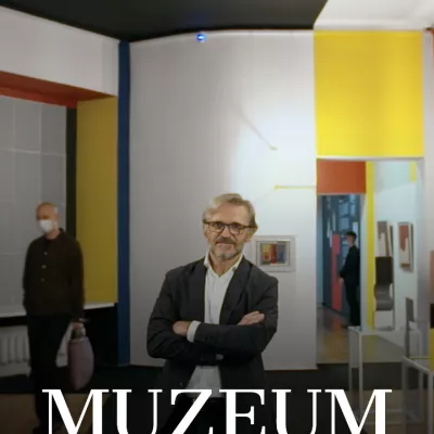 Dyrektor Muzeum Sztuki w Łodzi Jarosław Suchan stojący na tle sali wystawowej