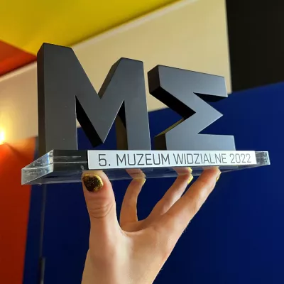 Statuetka Muzeum Widzialne, w tle Sala Neoplastyczna