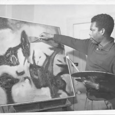 Black and white photo of an artist painting a picture