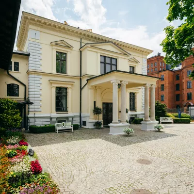 Kolorowe zdjęcie budynku, elewacja utrzymana jest w jasnych barwach