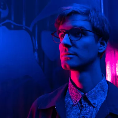 A person illuminated by colored lights