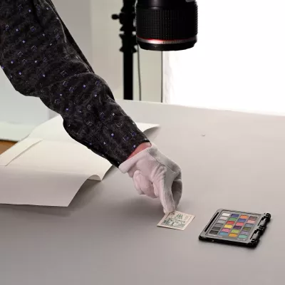 A hand touching small pieces of paper, a color picker next to it